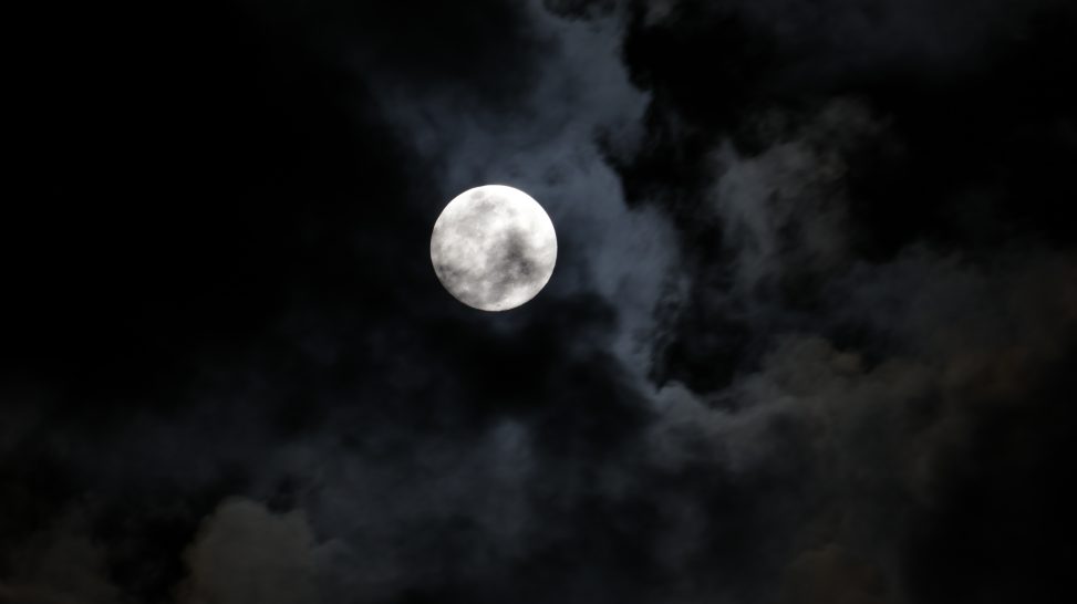 Photo of the full moon through cloud cover